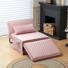 a pink bed sitting on top of a wooden floor in front of a fire place