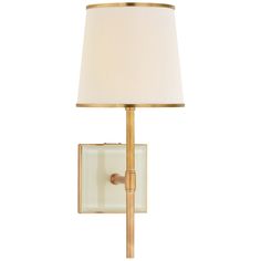 a wall light with a white shade on the side and a gold frame around it