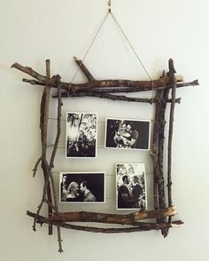 a group of pictures hanging on a wall next to some sticks and branches with photos pinned to them