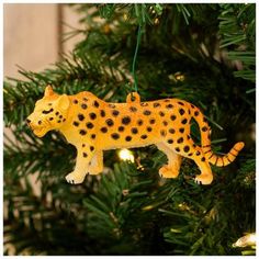 a christmas ornament shaped like a cheetah hanging from a pine tree