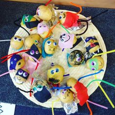 a wooden plate topped with lots of different types of potato head decorations on top of a blue rug