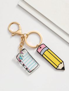 a pencil and eraser shaped keychain on a white surface