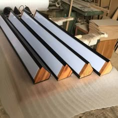 several pieces of metal and wood sitting on top of a piece of plywood in a workshop