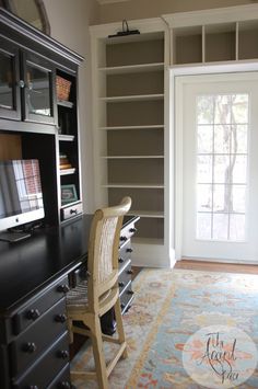 a desk and chair in a room with built - in bookcases