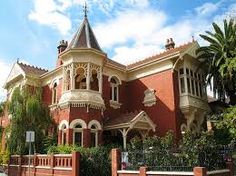 a large red brick house with an ornate roof and turret window on the top floor