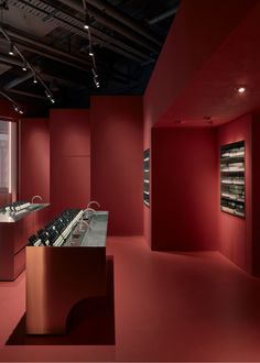 an empty room with red walls and lots of counter space in front of the window