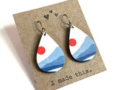 the earrings are made from wood and have red, white, and blue designs on them