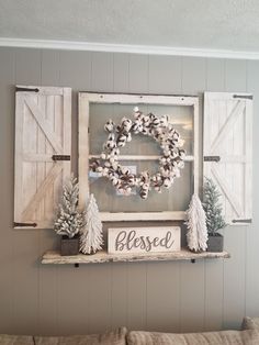 a living room decorated for christmas with wreaths and pine trees on the wall above