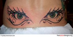 an eye tattoo on the side of a woman's stomach