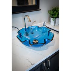 a blue glass bowl sink sitting on top of a counter