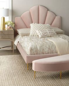 a pink bed sitting in a bedroom next to a dresser and lamp on top of a rug