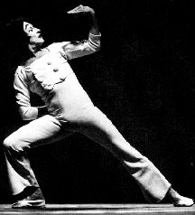 a man in white is dancing on stage