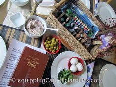 the table is set with plates, bowls, and an open book on top of it