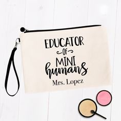 a white bag with the words education of mini humans on it next to some makeup brushes