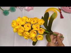 a person is arranging yellow flowers on a table