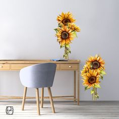 two large sunflowers sitting on top of a wooden table next to a desk