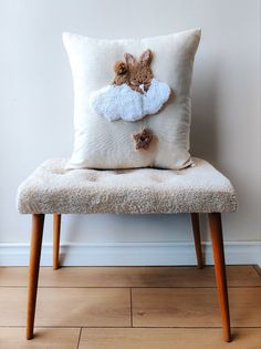 a stuffed animal is sitting on top of a pillow that has been placed on a bench