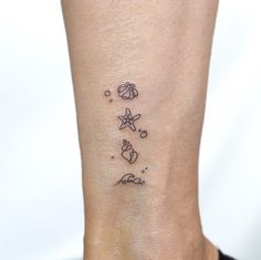 a woman's foot with a small tattoo on the ankle and starfishs