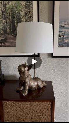 a dog figurine sitting on top of a wooden table next to a lamp