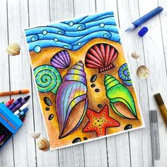 a drawing of two seashells and starfish on a white wooden table with colored pencils