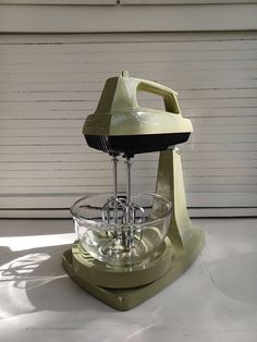 a stand mixer sitting on top of a white counter next to a wall and door