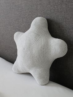 a crochet star pillow sitting on top of a bed with the text, free crochet pattern