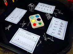 a black tray topped with lots of different types of paper and paintbrushes on top of it