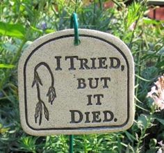 a sign that says, tried but it died in front of some bushes and flowers