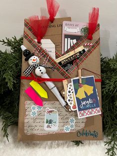 an open envelope with christmas cards and other items on it, wrapped in brown paper