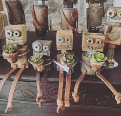 three wooden robot planters sitting on top of a table