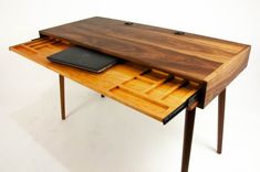 a wooden desk with an open drawer on it's side and a laptop in the middle