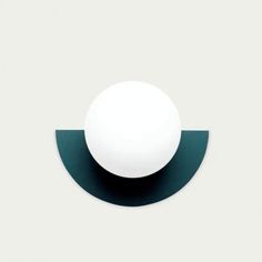 a white ball sitting on top of a black and green wall mounted light switch plate