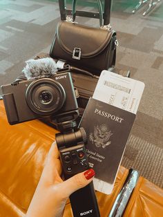 a person holding a camera and some luggage