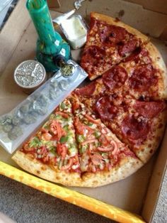 a pizza in a box with several different toppings and a knife next to it