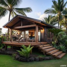 a small wooden house sitting on top of a lush green field next to palm trees