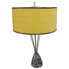 a table lamp with a yellow shade on the bottom and black wire at the base