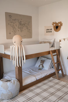 a wooden bunk bed with an octopus stuffed animal on it's head and legs