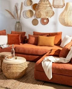 a living room with orange couches and wicker baskets on the wall above them