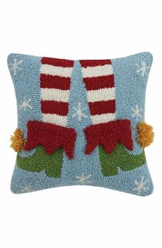 a blue pillow with two red and white striped stockings on the front, sitting on top of it