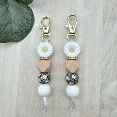 two key chains with flowers and beads attached to them