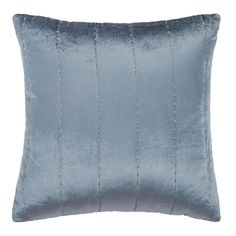 a blue velvet pillow with beading on the front and back, sitting on a white background