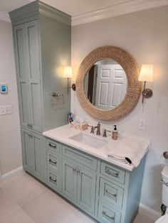 a bathroom with two sinks and a large round mirror above the sink is painted blue