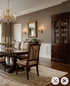 a formal dining room with chandelier, china cabinet and table in the center