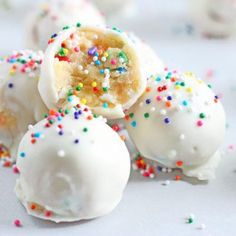 white chocolate covered donuts with sprinkles and colored powdered sugar on top