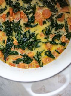 a pot filled with vegetables and cheese on top of a table