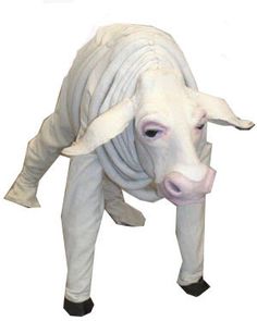 a statue of a white cow with black feet and legs, standing in front of a white background