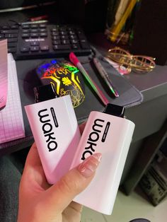 someone is holding two lighters with the word korok on them in front of a desk