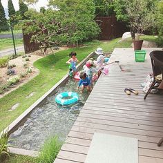 children playing in the water on an inflatable raft at a backyard pool area