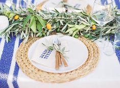 a place setting with olives and greenery