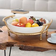 a white bowl filled with fruit on top of a wooden table